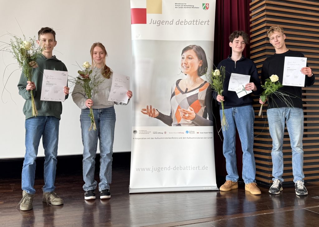 Die Schulsieger bei der Preisverleihung mit ihren Urkunden auf der Bühne