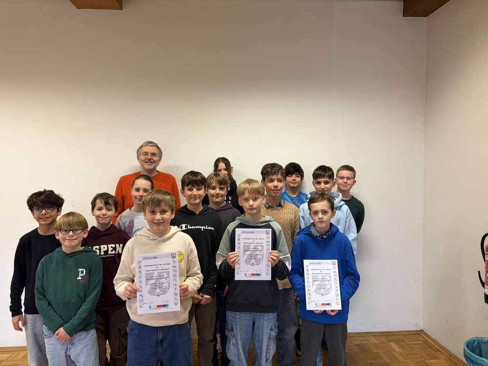 Die Mitglieder der Schachgruppe halten ihre Urkunden hoch.