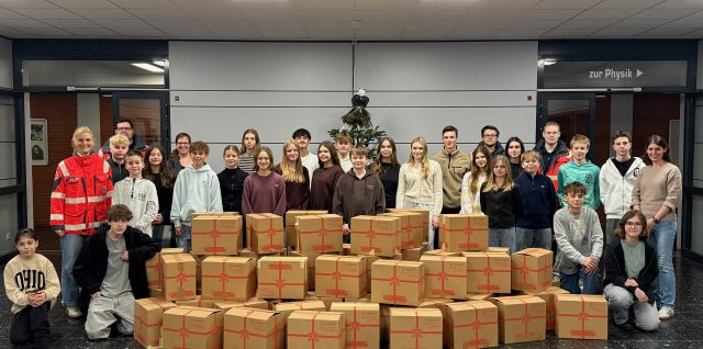 Schülerinnen und Schüler mit den von ihnen zusammengestellten und gepackten Hilfspaketen